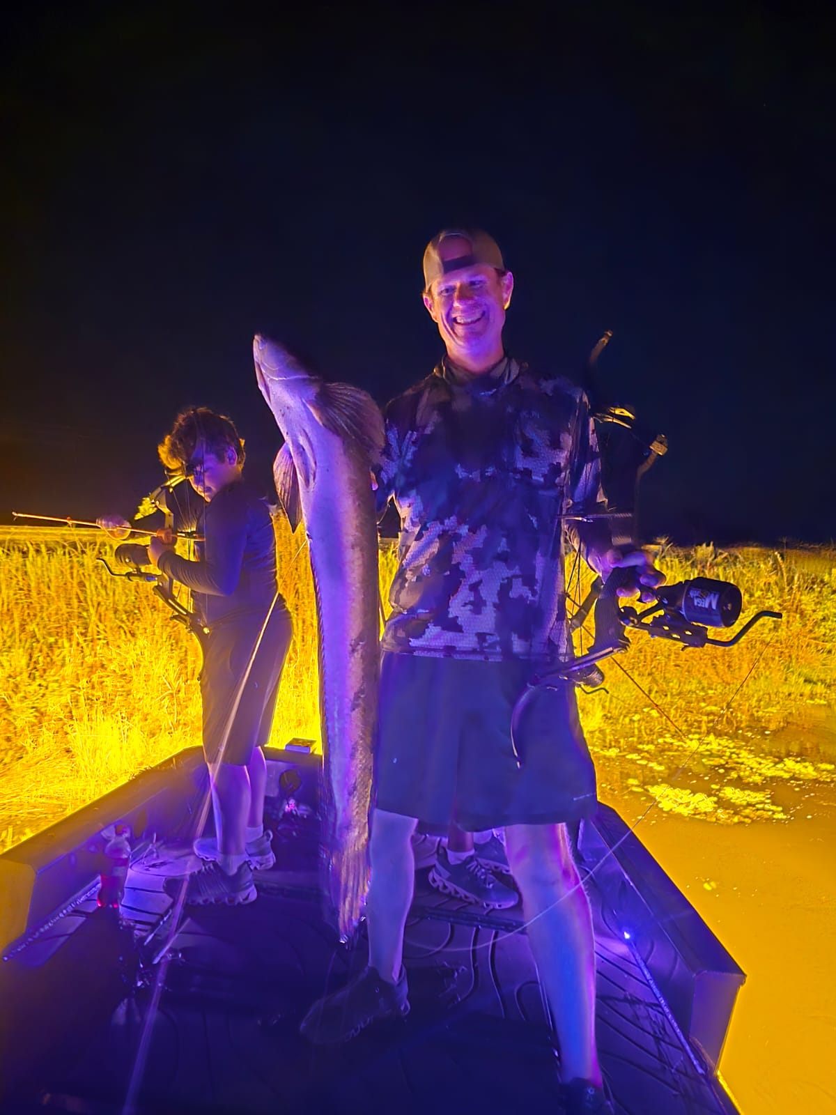 Native Roots Outdoors bowfishing trip photo with guests, fish, boat lights, and South Florida water