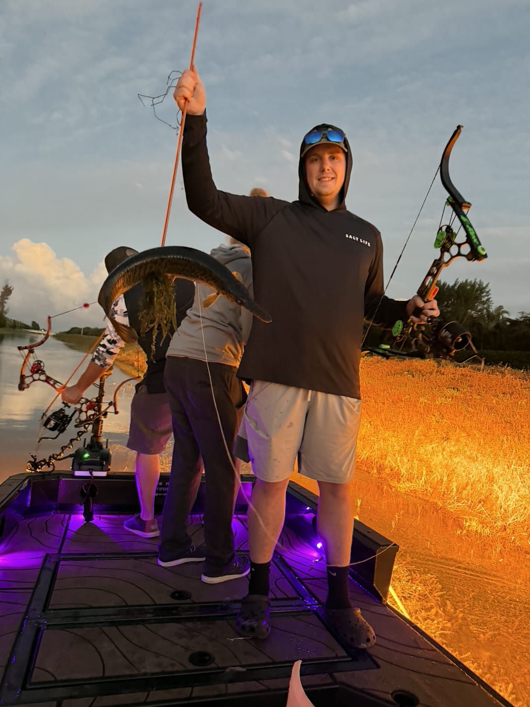 Native Roots Outdoors bowfishing trip photo with guests, fish, boat lights, and South Florida water