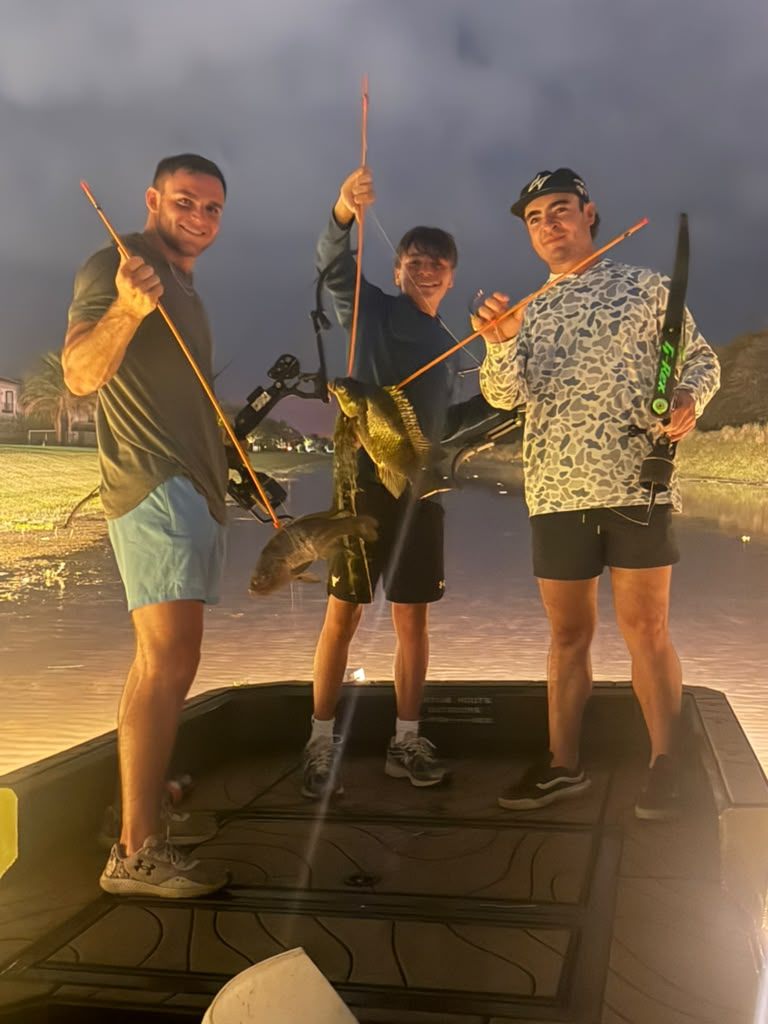 Native Roots Outdoors bowfishing trip photo with guests, fish, boat lights, and South Florida water