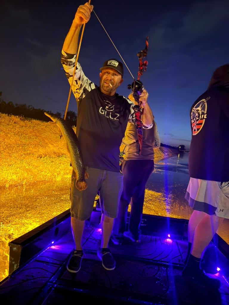 Native Roots Outdoors bowfishing trip photo with guests, fish, boat lights, and South Florida water