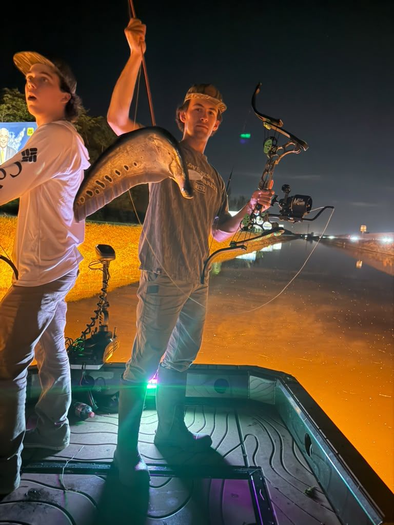 Native Roots Outdoors bowfishing trip photo with guests, fish, boat lights, and South Florida water