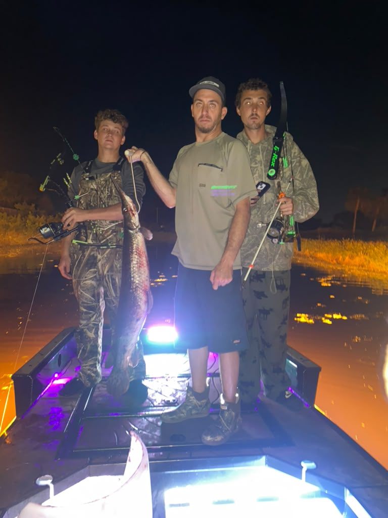Native Roots Outdoors bowfishing trip photo with guests, fish, boat lights, and South Florida water