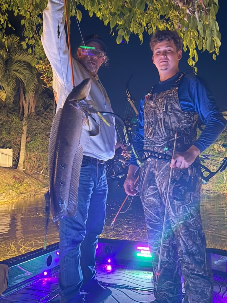 Native Roots Outdoors bowfishing trip photo with guests, fish, boat lights, and South Florida water