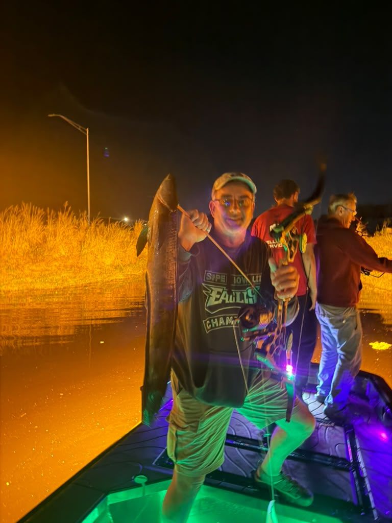 Native Roots Outdoors bowfishing trip photo with guests, fish, boat lights, and South Florida water