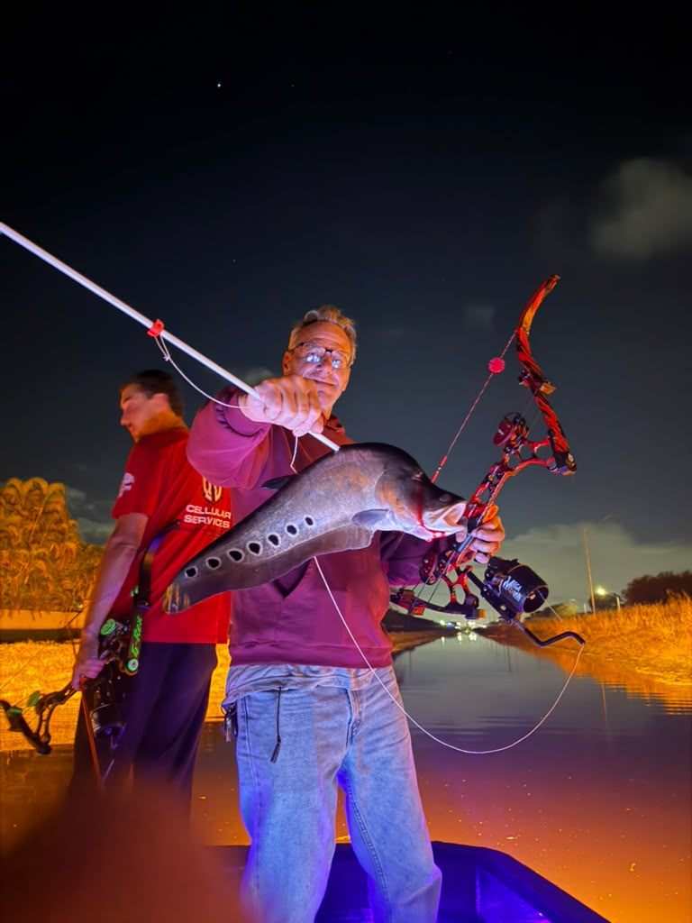 Native Roots Outdoors bowfishing trip photo with guests, fish, boat lights, and South Florida water