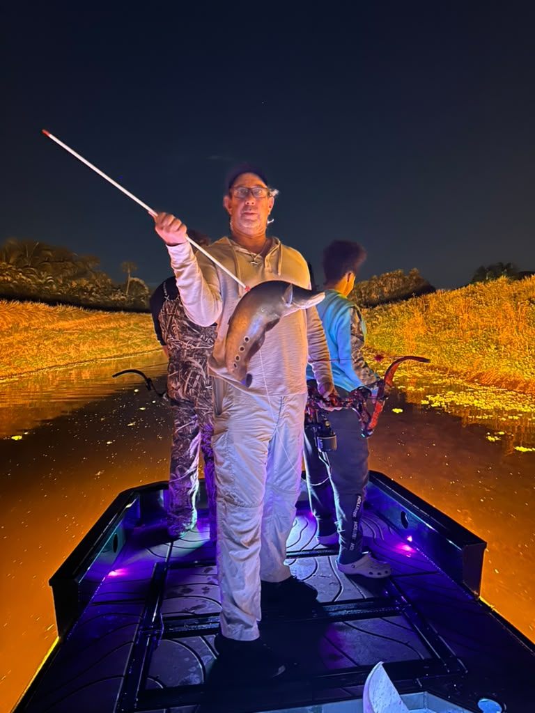 Native Roots Outdoors bowfishing trip photo with guests, fish, boat lights, and South Florida water